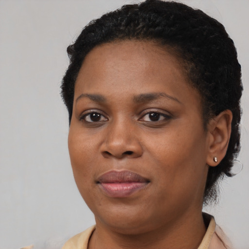 Joyful black young-adult female with short  black hair and brown eyes