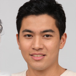 Joyful asian young-adult male with short  brown hair and brown eyes