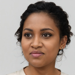 Joyful black young-adult female with long  brown hair and brown eyes