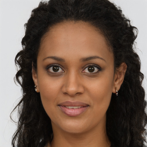 Joyful black young-adult female with long  brown hair and brown eyes