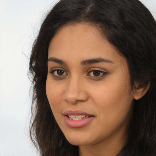 Joyful latino young-adult female with long  brown hair and brown eyes