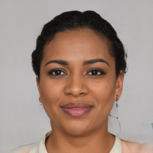 Joyful black young-adult female with short  black hair and brown eyes