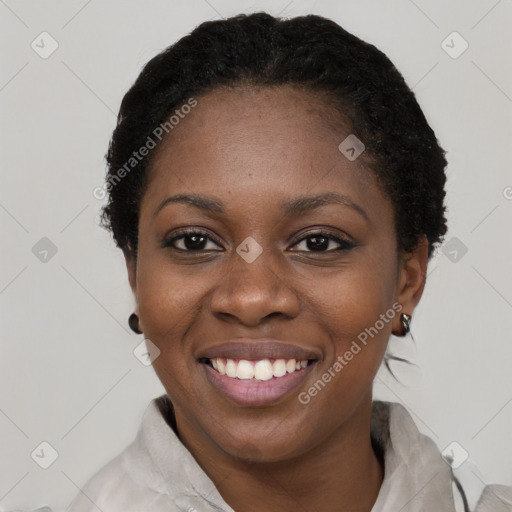 Joyful black young-adult female with short  black hair and brown eyes