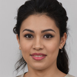 Joyful latino young-adult female with medium  brown hair and brown eyes