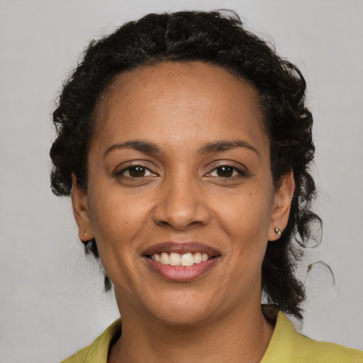 Joyful black adult female with medium  brown hair and brown eyes