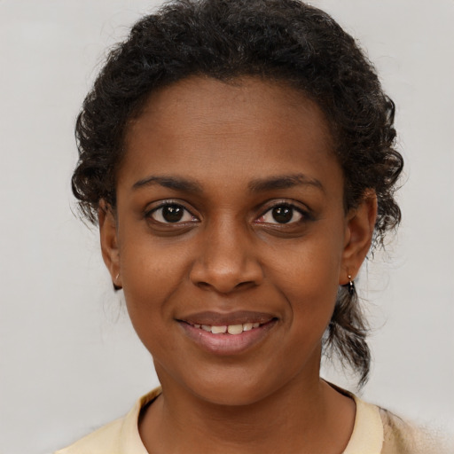 Joyful black young-adult female with medium  brown hair and brown eyes