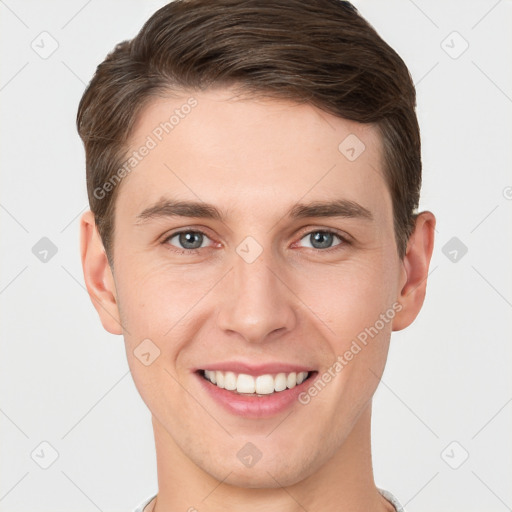 Joyful white young-adult male with short  brown hair and grey eyes