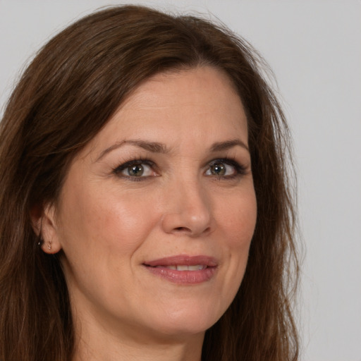 Joyful white adult female with long  brown hair and brown eyes