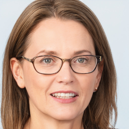 Joyful white adult female with long  brown hair and blue eyes