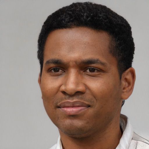 Joyful black young-adult male with short  black hair and brown eyes