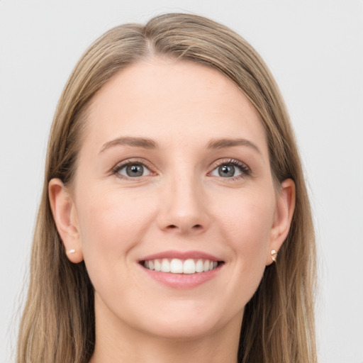 Joyful white young-adult female with long  brown hair and grey eyes