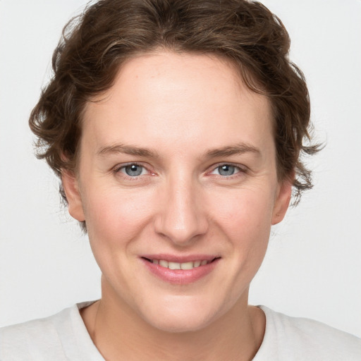 Joyful white young-adult female with short  brown hair and blue eyes