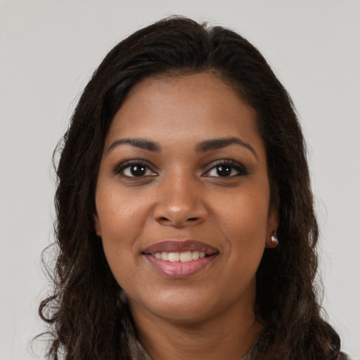 Joyful black young-adult female with long  brown hair and brown eyes