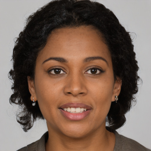 Joyful black young-adult female with medium  brown hair and brown eyes