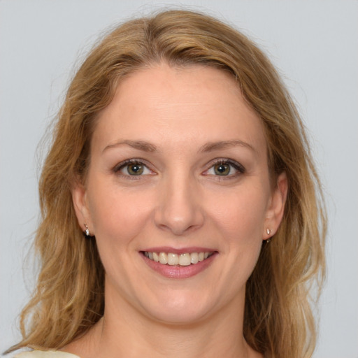 Joyful white young-adult female with medium  brown hair and green eyes