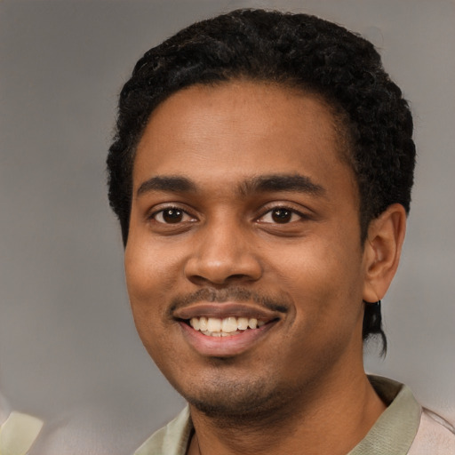 Joyful black young-adult male with short  black hair and brown eyes