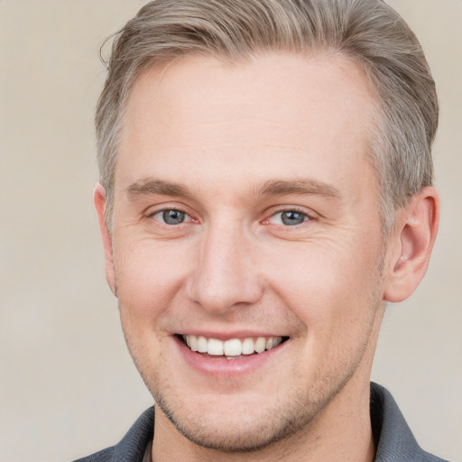 Joyful white adult male with short  brown hair and grey eyes