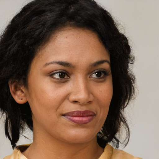 Joyful black young-adult female with medium  brown hair and brown eyes