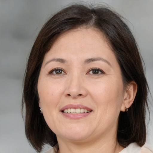 Joyful white adult female with medium  brown hair and brown eyes