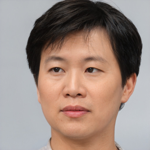 Joyful asian young-adult male with short  brown hair and brown eyes