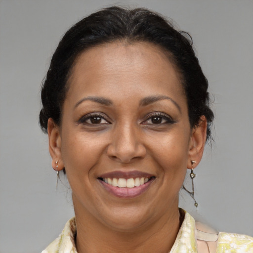Joyful latino adult female with medium  brown hair and brown eyes