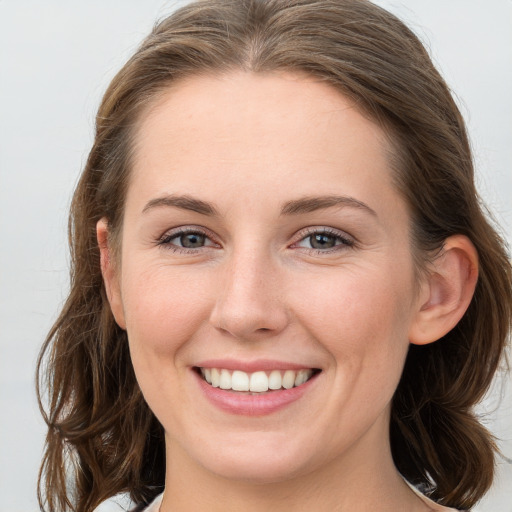 Joyful white young-adult female with long  brown hair and grey eyes