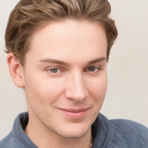 Joyful white young-adult male with short  brown hair and blue eyes