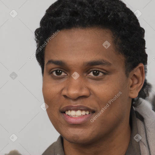 Joyful black young-adult male with short  black hair and brown eyes