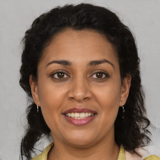 Joyful latino adult female with medium  brown hair and brown eyes