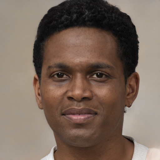 Joyful black young-adult male with short  black hair and brown eyes