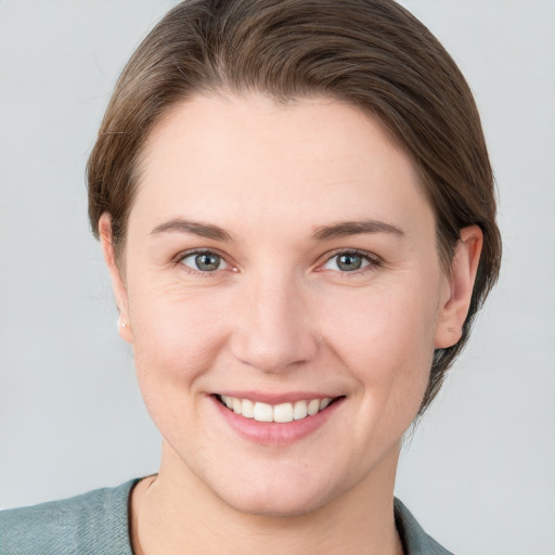 Joyful white young-adult female with short  brown hair and grey eyes