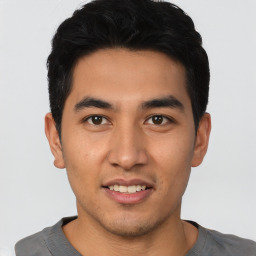 Joyful asian young-adult male with short  black hair and brown eyes