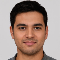 Joyful latino young-adult male with short  black hair and brown eyes