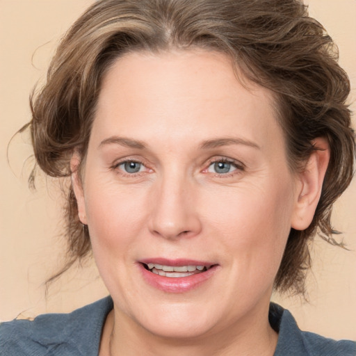 Joyful white adult female with medium  brown hair and grey eyes