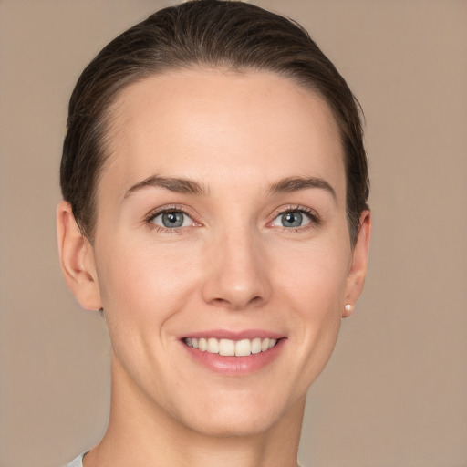 Joyful white young-adult female with short  brown hair and grey eyes