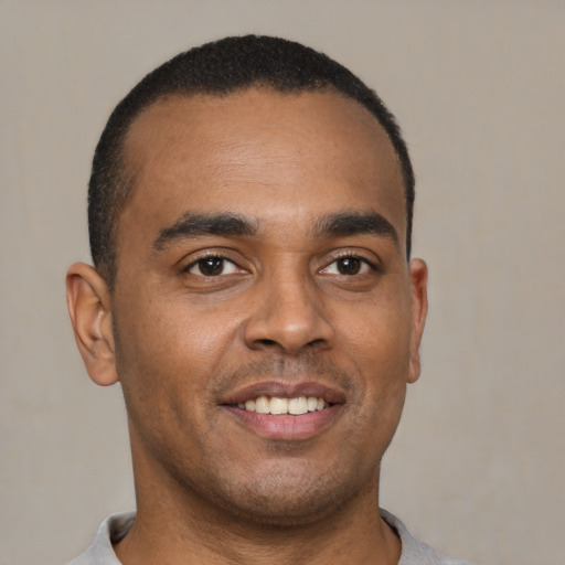 Joyful latino young-adult male with short  brown hair and brown eyes