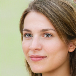 Joyful white young-adult female with long  brown hair and green eyes