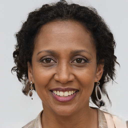 Joyful black adult female with medium  brown hair and brown eyes