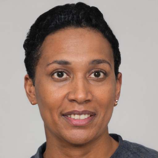 Joyful black adult female with short  black hair and brown eyes