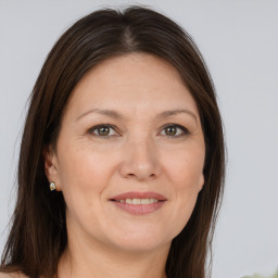 Joyful white adult female with long  brown hair and brown eyes