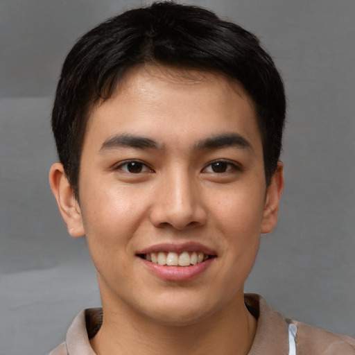 Joyful asian young-adult male with short  brown hair and brown eyes