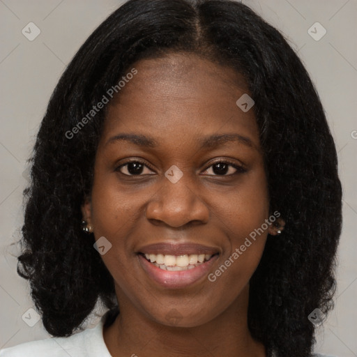 Joyful black young-adult female with long  brown hair and brown eyes