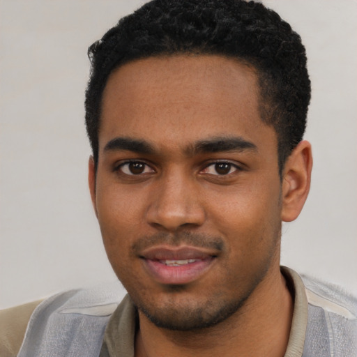 Joyful black young-adult male with short  black hair and brown eyes
