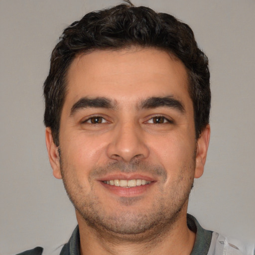 Joyful white young-adult male with short  brown hair and brown eyes