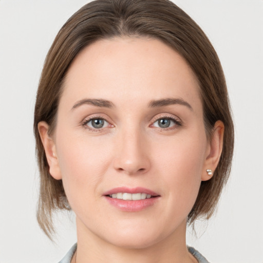 Joyful white young-adult female with medium  brown hair and grey eyes