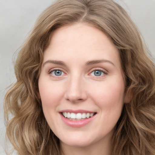 Joyful white young-adult female with long  brown hair and blue eyes