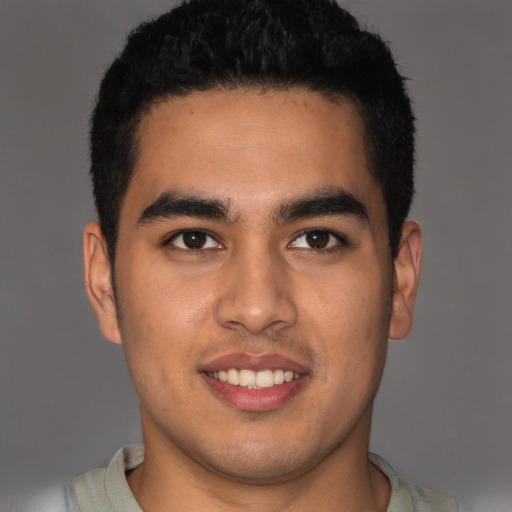Joyful latino young-adult male with short  black hair and brown eyes