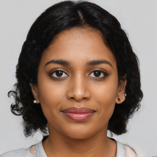 Joyful black young-adult female with long  black hair and brown eyes