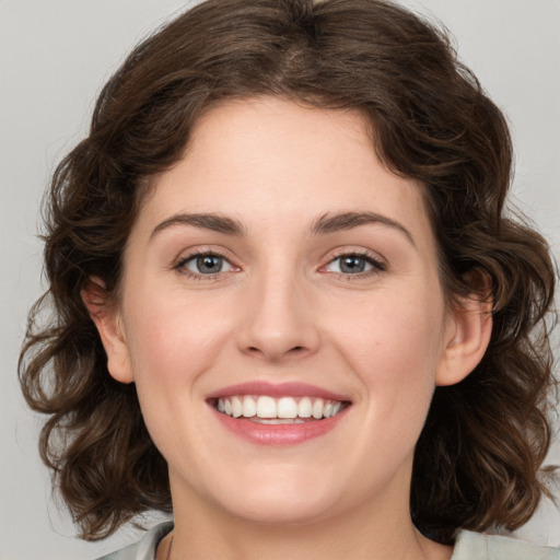 Joyful white young-adult female with medium  brown hair and green eyes