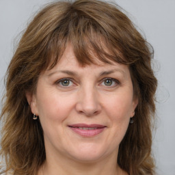 Joyful white adult female with medium  brown hair and grey eyes